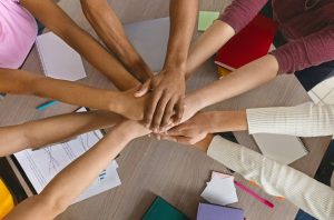 International college students stacking their hands together