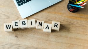 wooden cubes with webinar letters near laptop