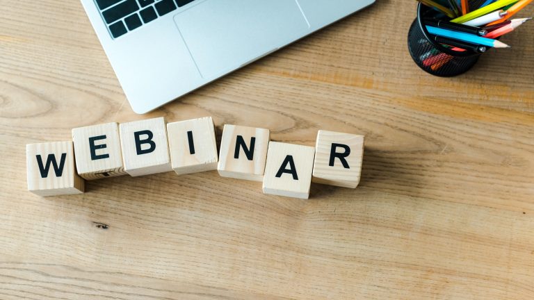 wooden cubes with webinar letters near laptop